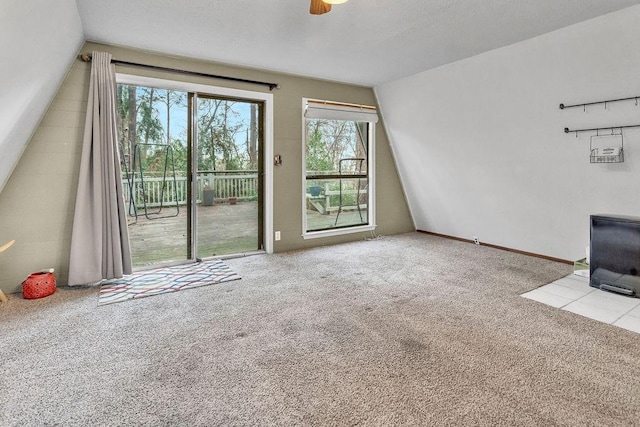 unfurnished living room featuring ceiling fan, light colored carpet, and vaulted ceiling