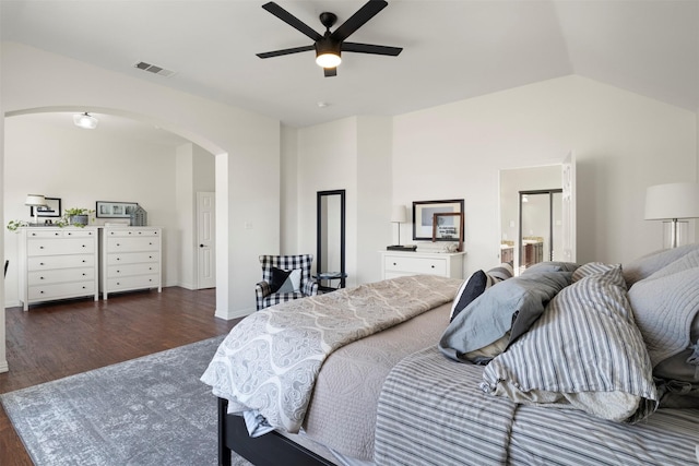 bedroom featuring dark wood-type flooring, ceiling fan, vaulted ceiling, and ensuite bath