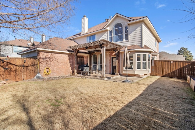 rear view of property featuring a yard, a pergola, and a patio area