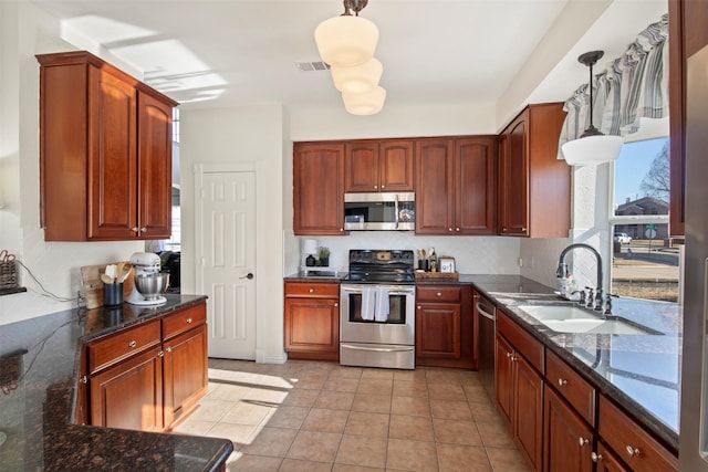 kitchen featuring sink, tasteful backsplash, light tile patterned floors, pendant lighting, and stainless steel appliances