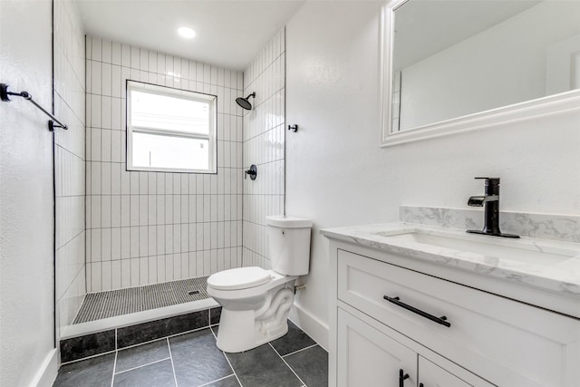 bathroom with vanity, tile patterned floors, toilet, and a tile shower