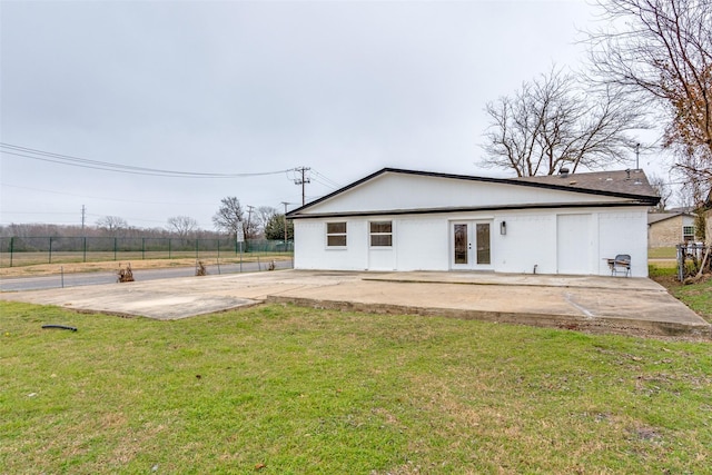 back of property featuring a patio, a yard, and french doors