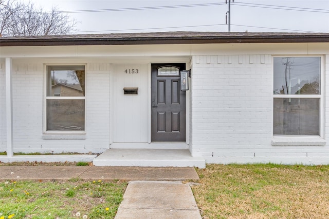 property entrance with a lawn