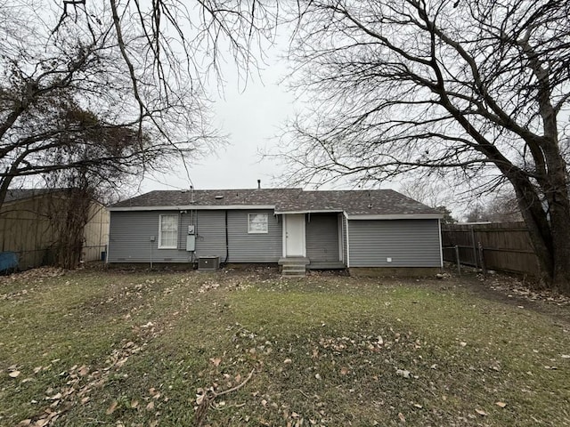 back of property featuring central AC unit and a lawn