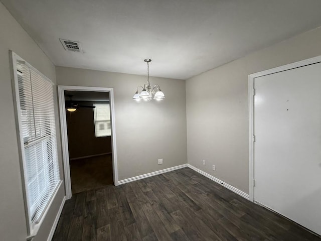 unfurnished dining area with dark hardwood / wood-style floors and a notable chandelier