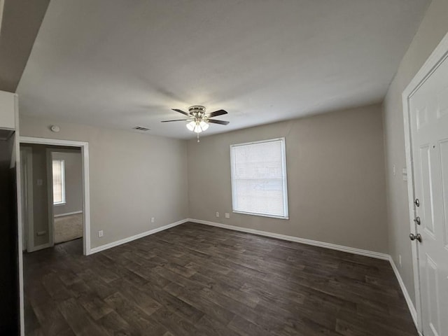 empty room featuring ceiling fan and dark hardwood / wood-style flooring