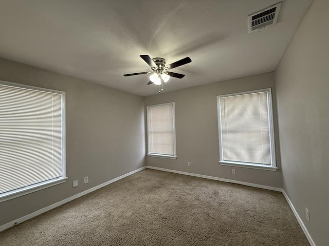 carpeted spare room featuring ceiling fan