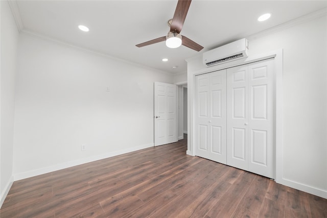 unfurnished bedroom featuring crown molding, dark hardwood / wood-style floors, a wall mounted air conditioner, and a closet