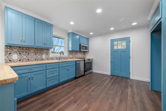 kitchen featuring dark wood-style floors, wooden counters, blue cabinetry, a sink, and stainless steel appliances