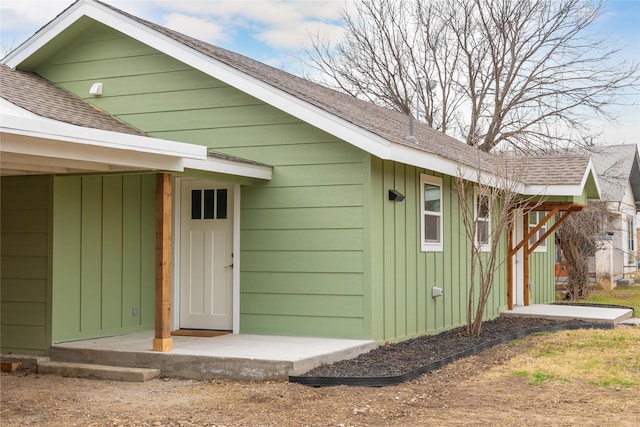 view of home's exterior with board and batten siding and roof with shingles