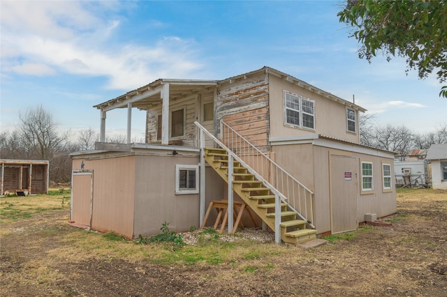 rear view of property with stairway