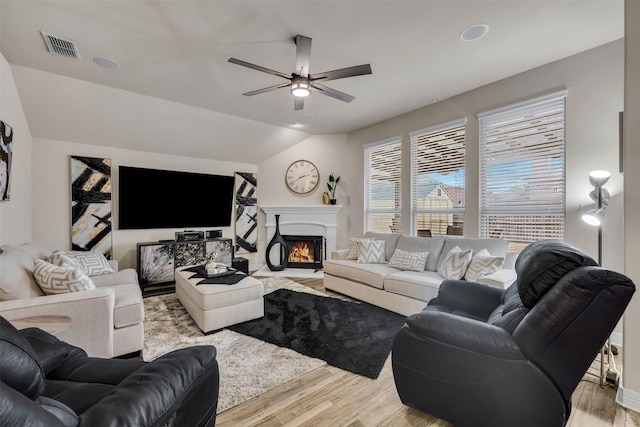 living room featuring ceiling fan, vaulted ceiling, and light wood-type flooring