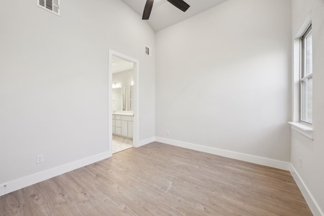 unfurnished room with ceiling fan, vaulted ceiling, and light wood-type flooring