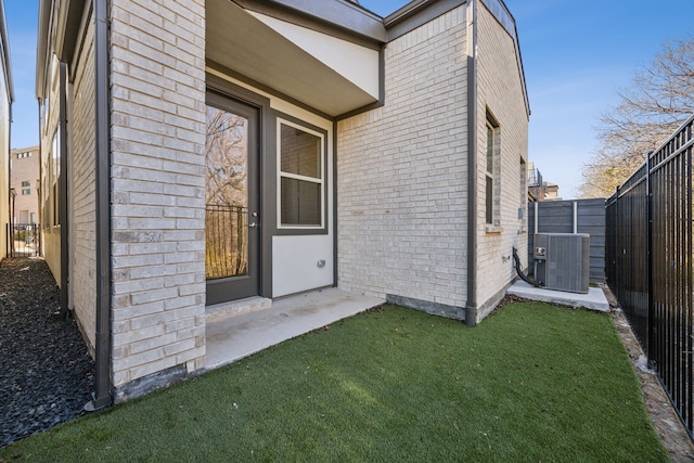 doorway to property with a lawn and central air condition unit