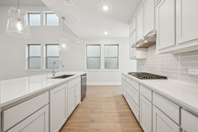 kitchen featuring white cabinetry, decorative light fixtures, and stainless steel appliances