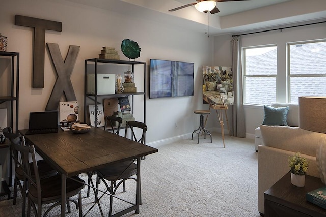 dining room with carpet, ceiling fan, and a tray ceiling