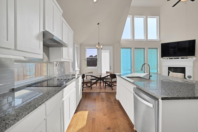 kitchen with an island with sink, sink, stainless steel dishwasher, and white cabinets