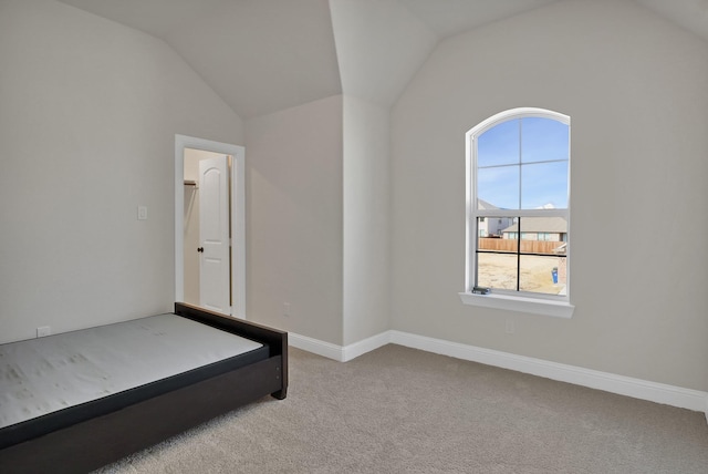 unfurnished bedroom with lofted ceiling and light carpet