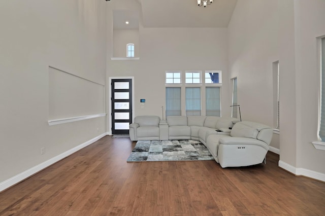 unfurnished living room featuring hardwood / wood-style floors and a high ceiling