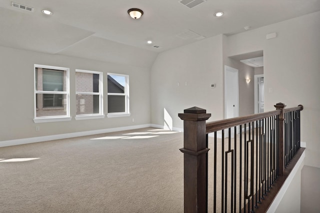 hallway featuring lofted ceiling and carpet floors