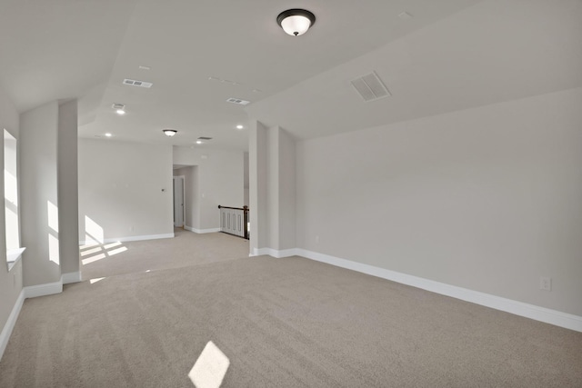 spare room featuring lofted ceiling and light carpet