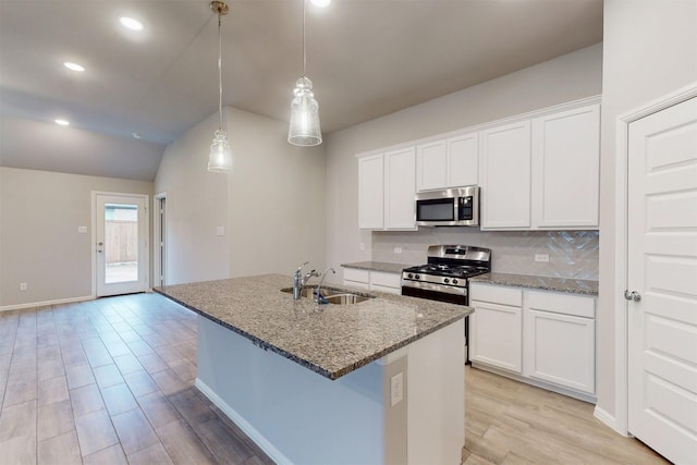 kitchen featuring sink, white cabinetry, decorative light fixtures, stainless steel appliances, and a kitchen island with sink