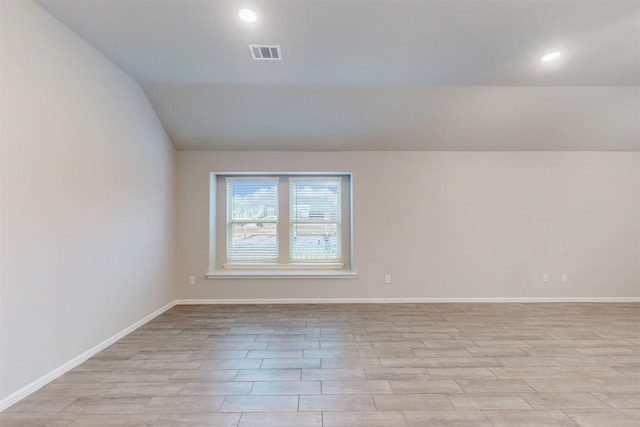 unfurnished room with lofted ceiling and light hardwood / wood-style floors