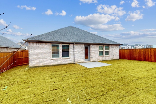 rear view of property featuring a yard and a patio