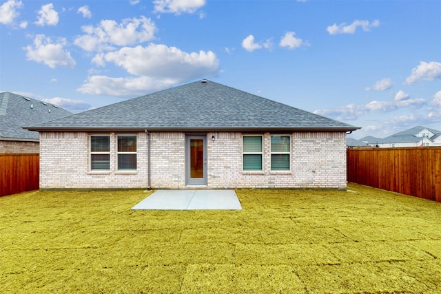 rear view of property featuring a yard and a patio area