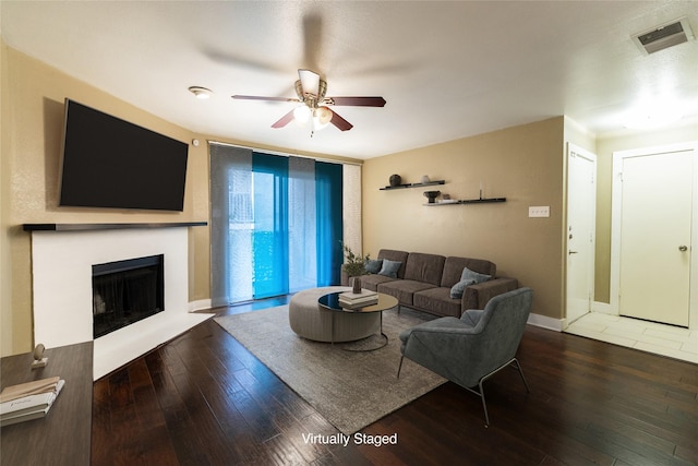 living room with dark wood-type flooring and ceiling fan