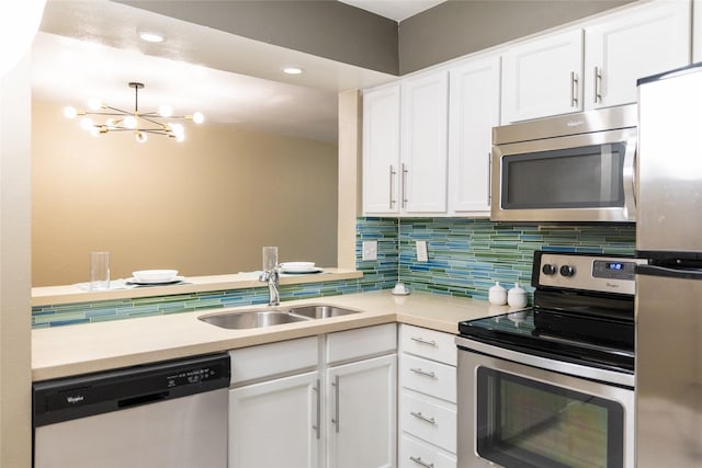 kitchen featuring sink, appliances with stainless steel finishes, backsplash, a notable chandelier, and white cabinets