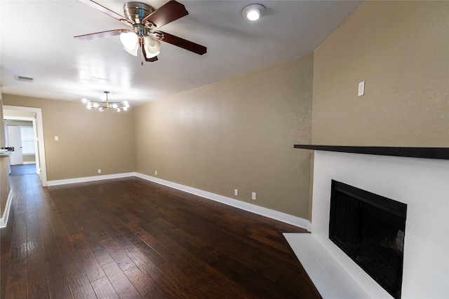 unfurnished living room with dark hardwood / wood-style floors and ceiling fan with notable chandelier