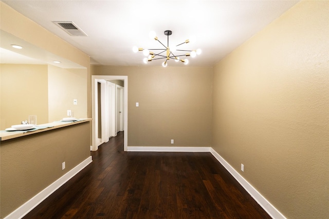 unfurnished dining area with an inviting chandelier and dark wood-type flooring