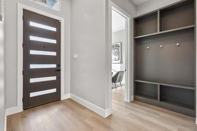 foyer with light wood-style flooring and baseboards