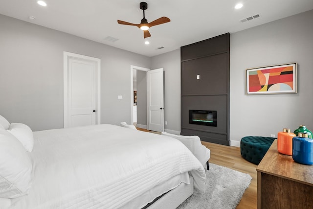 bedroom featuring recessed lighting, visible vents, a large fireplace, ceiling fan, and light wood-type flooring