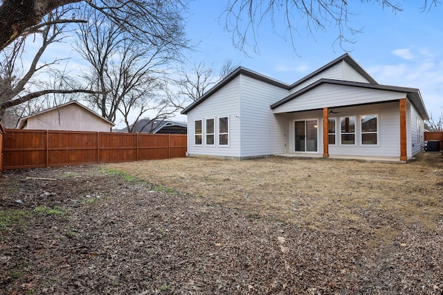 back of property with cooling unit, fence, and a ceiling fan