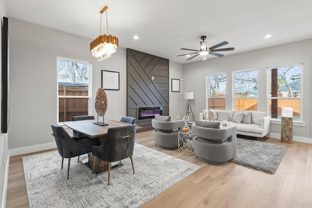 dining room featuring a wealth of natural light, a fireplace, recessed lighting, and wood finished floors