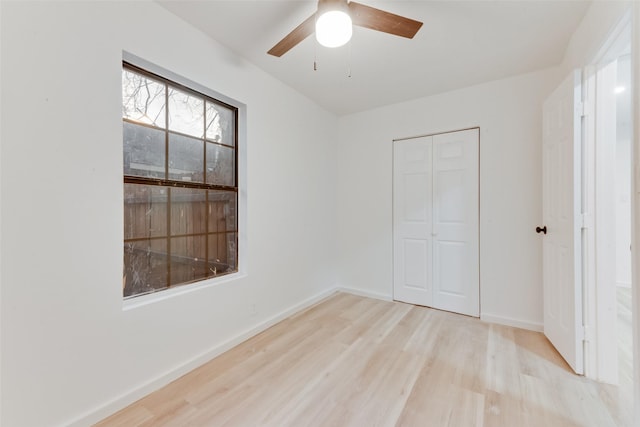 unfurnished bedroom featuring ceiling fan, light wood-type flooring, and a closet