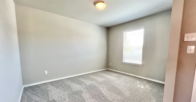 carpeted empty room featuring baseboards