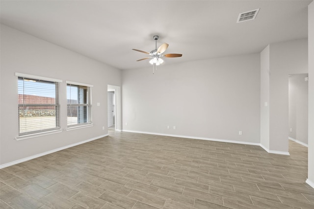 empty room with light wood-type flooring, baseboards, visible vents, and a ceiling fan