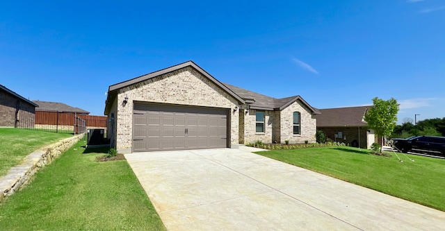 single story home featuring a garage and a front yard