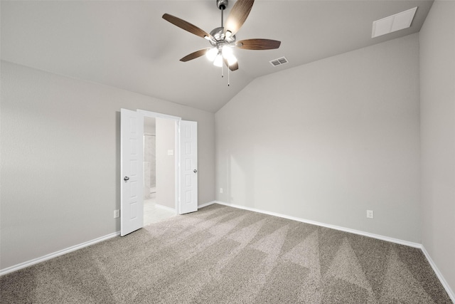 carpeted spare room with lofted ceiling, ceiling fan, visible vents, and baseboards