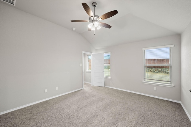 unfurnished bedroom with lofted ceiling, multiple windows, visible vents, and carpet