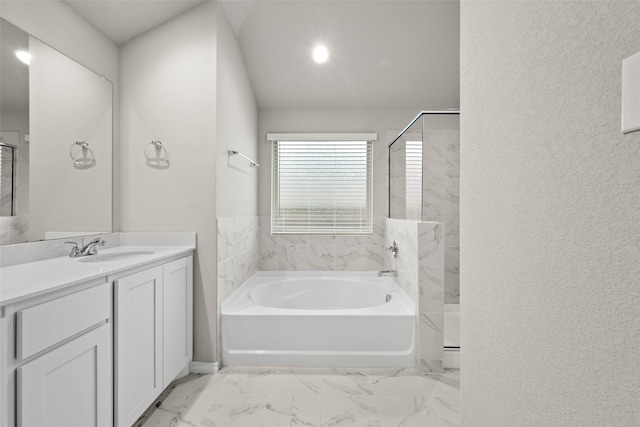 bathroom featuring a garden tub, vanity, and a walk in shower