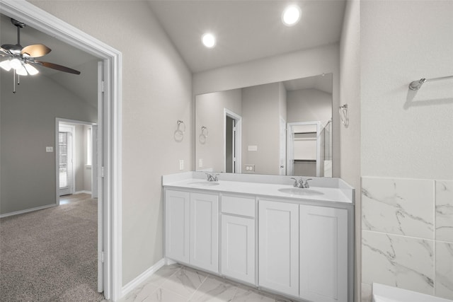 bathroom featuring lofted ceiling, double vanity, and a sink