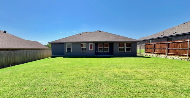 back of property featuring a lawn and a fenced backyard