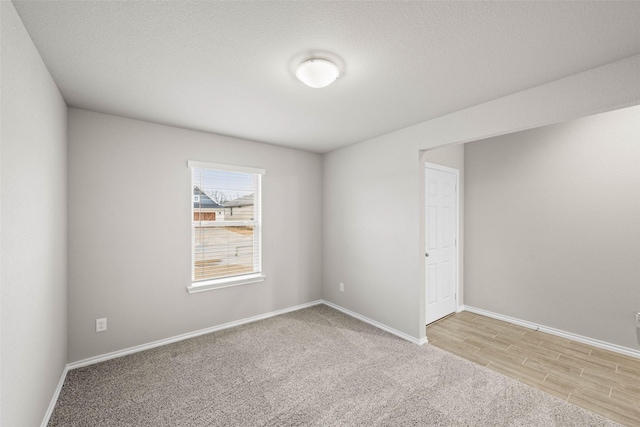 spare room featuring light wood-style floors and baseboards