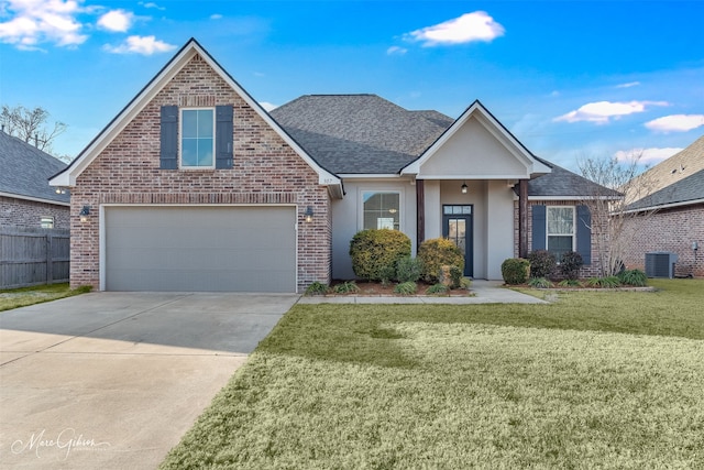 view of front of home featuring central AC, a garage, and a front yard