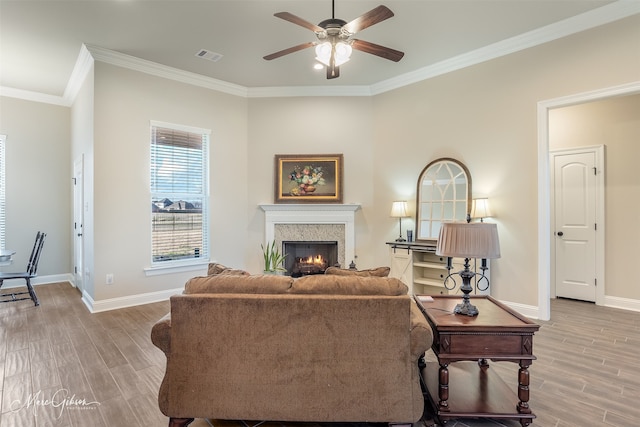 living room with crown molding, light hardwood / wood-style floors, and ceiling fan