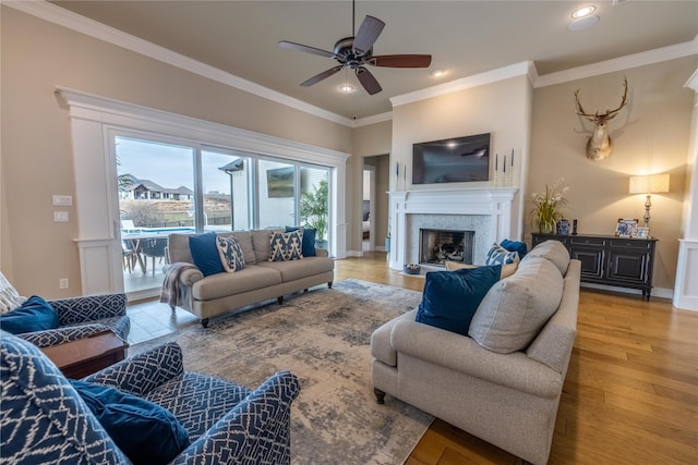 living room with ceiling fan, ornamental molding, and light wood-type flooring